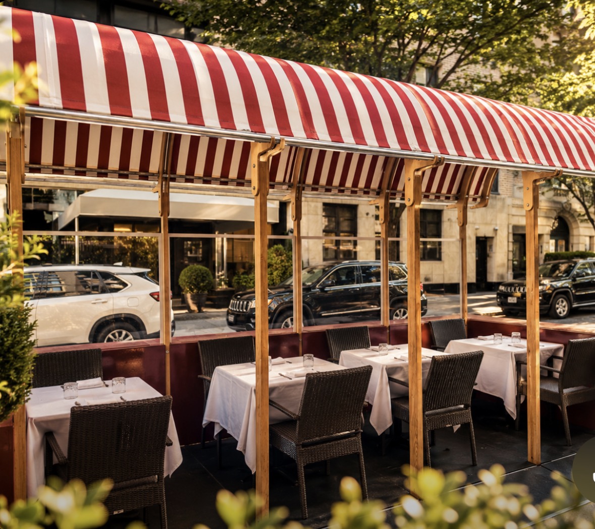 Caravaggio's Madison Avenue sidewalk terrace under signature red-and-white striped awning
